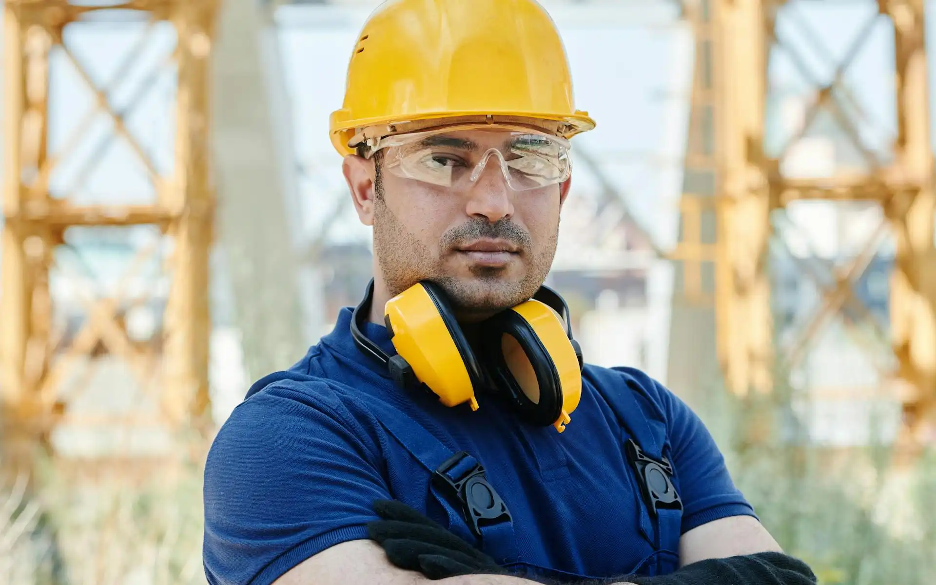 Man wearing head, eye and ear protection at an outdoor industrial site